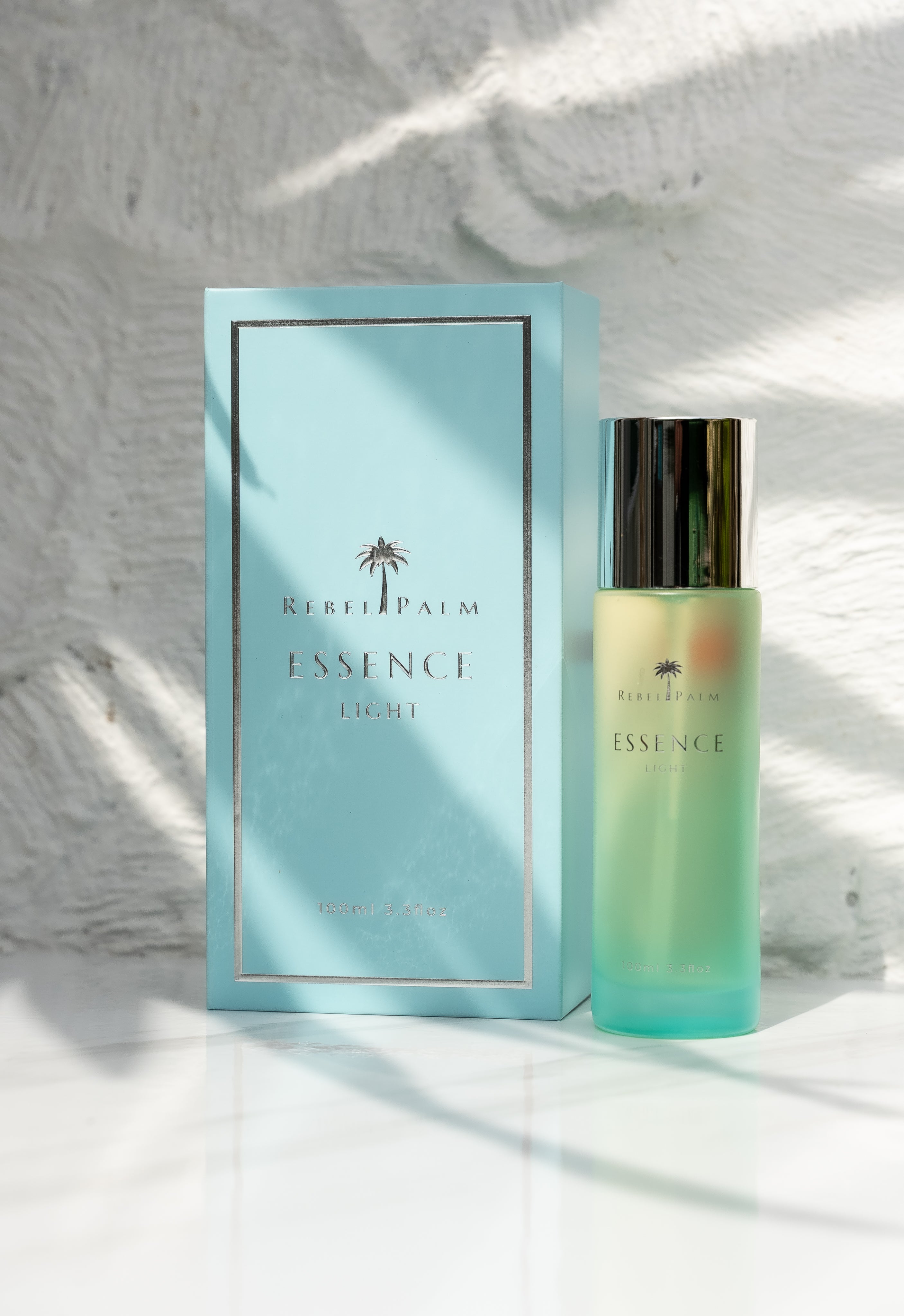 Rebel Palm Essence perfume bottle and packaging on a light background