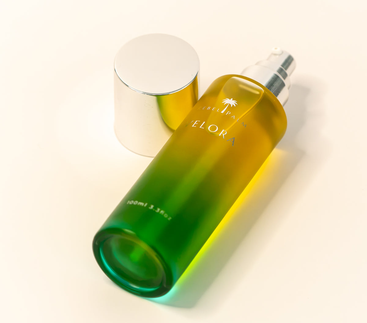 Rebel Palm Velora Night Body Oil 100ml glass bottle lying on its side with silver pump cap